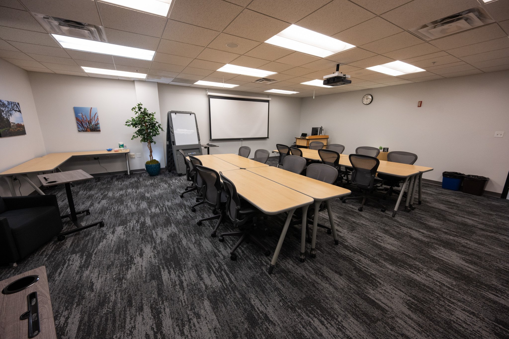 L243 instructional classroom with tables arranged for group collaboration and presentation