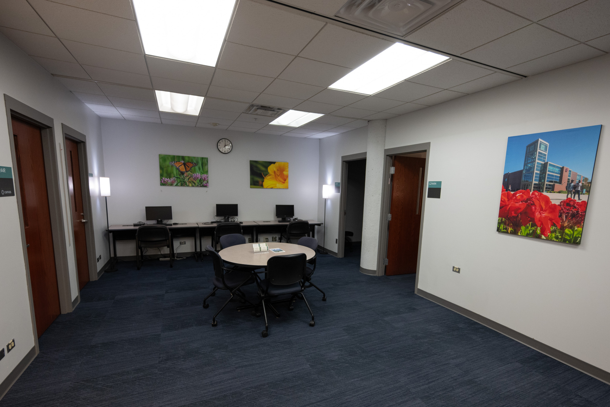 L244C faculty and staff workspace with computer stations, round meeting table, and chairs
