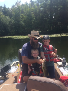 Eric DeVillez in a boat with his sons